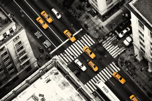 Horizontale fotografie van Manhattan straatbeeld met gele taxi’s, zebrapaden en stedelijke gebouwen vanuit luchtperspectief