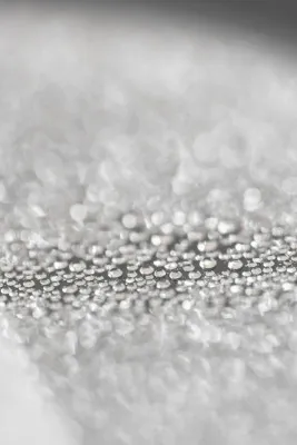 Verticale zwart-wit macrofotografie van regendruppels met zachte bokeh en zilveren tinten