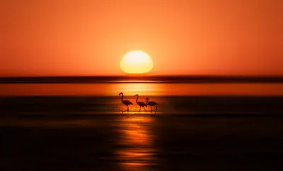 Horizontale landschapsfotografie van een warme zonsondergang boven Walvis Bay met kleurrijke lucht en reflecties op water