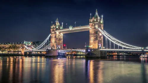Horizontale nachtelijke foto van de Tower Bridge in Londen met verlichte gebouwen en de rivier Thames