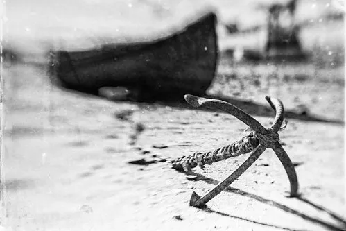 Zwart-wit horizontale fotografie van strand met ankers, boten en kustlijn in creatieve blur en textuur