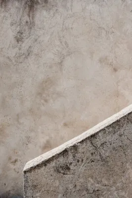 Verticale foto van een abstracte vintage muur met kalksteen, cement en schaduwen in zachte beige en grijstinten