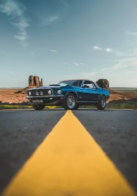 Verticale foto van een vintage muscle car op Route 66 in Arizona onder een bewolkte zomerlucht