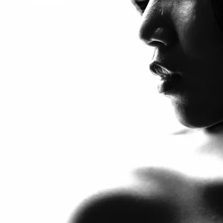 Vierkante zwart-wit high key portretfotografie van een gezicht met focus op lippen en een sensuele, emotionele uitstraling