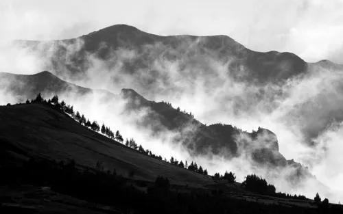 Zwart-witfotografie van de Andes bergen in Ecuador met mist en nevel, horizontale landschapsopname