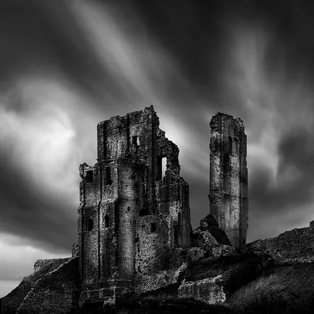 Zwart-wit vierkante foto van de ruïnes van Corfe Castle in Dorset met middeleeuwse stenen muren en bogen