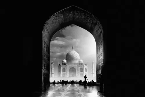 Zwart-wit fotografie van de Taj Mahal met focus op poort, bogen, koepels en silhouetten van mensen