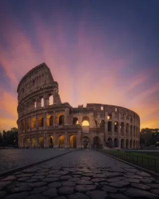 Verticale foto van het Colosseum in Rome bij zonsopgang met warme kleuren en heldere lucht