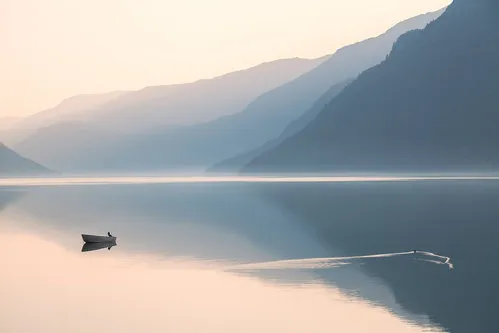 Horizontale foto van een stille avond bij Veitastrond, Noorwegen met mist, motorboten, vogels en mensen in een rustig natuurlandschap