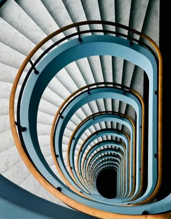 Verticale abstracte fotografie van een spiraaltrap in een interieur in Antwerpen met diverse kleuren en architectonische lijnen