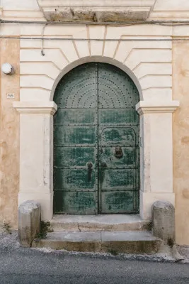 Verticale fotografie van een oude Italiaanse deur met deurklopper in Rossano, Calabria