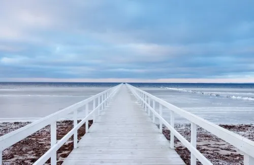 Horizontale foto van houten pier en zeezicht bij Malmö, Zweden met zachte zand- en blauwtinten