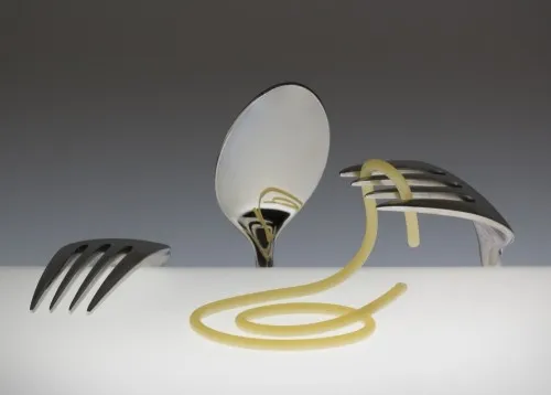 Vrouw met spaghetti in haar haar en bestek op tafel in een buitenrestaurant, horizontale food fotografie