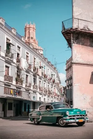 Verticale foto van een vintage auto in een smalle straat in Havana, Cuba met kleurrijke gebouwen