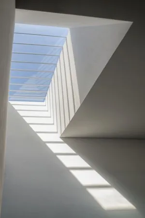 Verticale foto van lichtinval door dakraam in Salgueiros metrostation Porto met abstracte architectuur en schaduwen