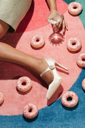 verticale foto outdoor scene met vrouwen in hoge hakken, champagne en roze pastelkleuren