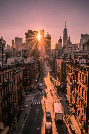 Verticale foto van New York straat met zonnestralen, gebouwen en verkeer bij zonsondergang
