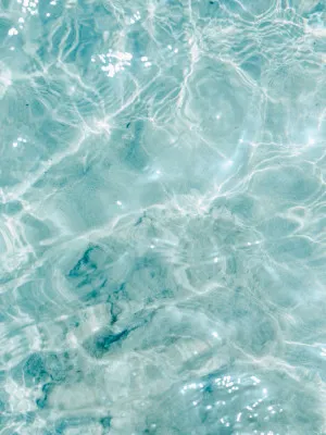 Verticale foto van turkoois water met zachte rimpelingen en abstracte textuur in zomerse buitenlucht