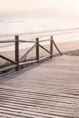 Verticale kustfoto met zand, zee en houten boardwalk aan een rustige strandzijde