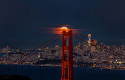 Fotografie van de Golden Gate Bridge en skyline van San Francisco bij volle maan en nachtelijke hemel