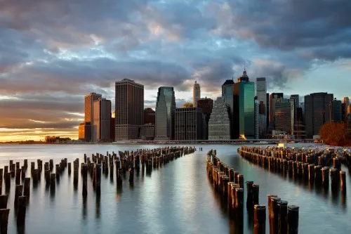 Horizontale foto van NYC skyline met wolkenkrabbers langs de Hudson rivier bij avondlicht