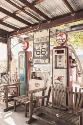 Verticale foto van een kleurrijk vintage tankstation langs Route 66 in Arizona, met opvallende brandstofpompen en retro borden
