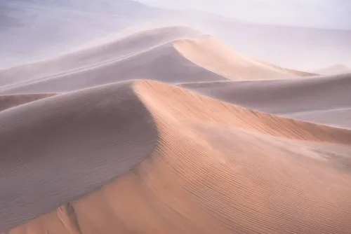 Fotografie van wind die zandduinen in Death Valley Californië zacht doet golven, horizontaal landschap met bruine tinten
