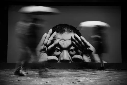 Zwart-wit horizontale stadsfoto met lopende mensen, paraplu’s en natte straten in de regen