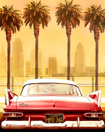 Verticale foto van een klassieke rode Plymouth Savoy geparkeerd onder palmbomen met de skyline van Los Angeles op de achtergrond
